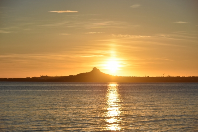 水平線に浮かぶ伊江島と夕陽